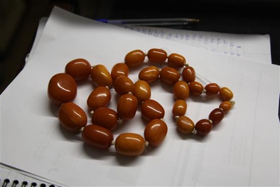 A single strand graduated oval amber bead necklace, 80cm.